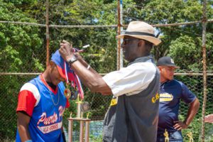 a man placing medals on a baseball player